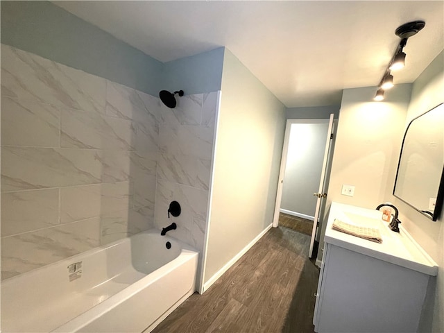 bathroom with tiled shower / bath combo, wood-type flooring, and vanity