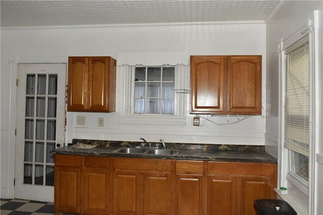 kitchen featuring a sink, ornamental molding, and brown cabinetry