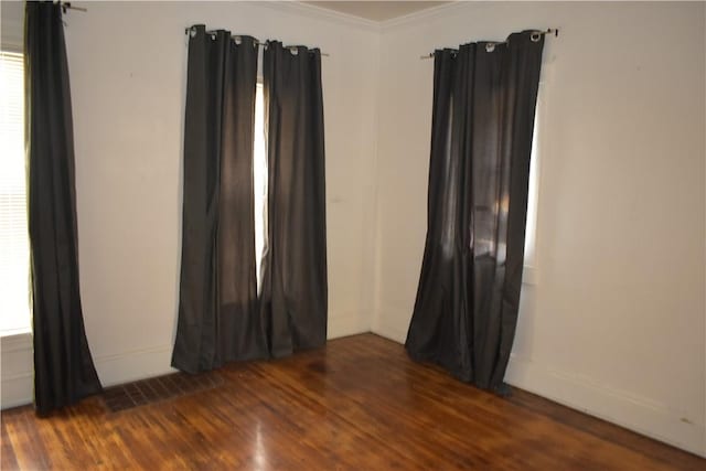 spare room featuring crown molding and dark hardwood / wood-style flooring