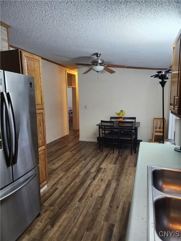 kitchen featuring dark hardwood / wood-style flooring, ceiling fan, stainless steel fridge, and a textured ceiling