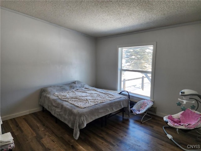 bedroom featuring ornamental molding, dark hardwood / wood-style floors, and a textured ceiling