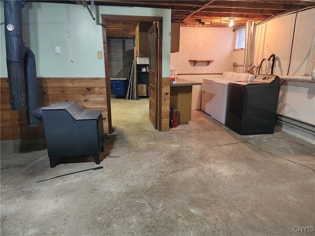 basement featuring washing machine and dryer and a wood stove