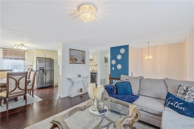 living room with dark hardwood / wood-style floors and a notable chandelier