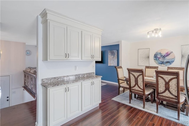 kitchen with white cabinetry, dark hardwood / wood-style flooring, and light stone countertops