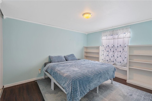 bedroom featuring crown molding and dark hardwood / wood-style floors