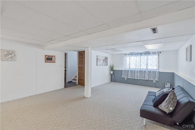 basement with a paneled ceiling and carpet