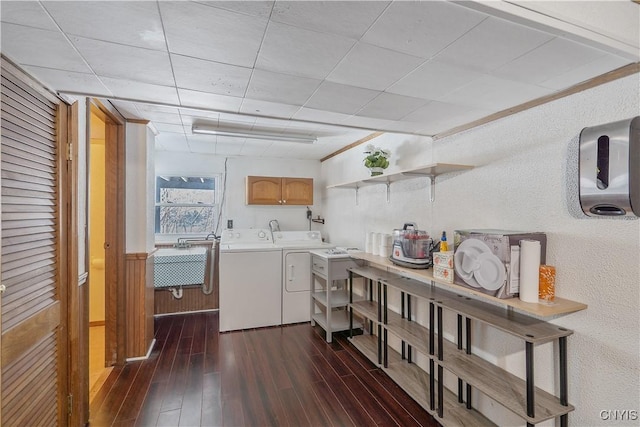 laundry room featuring dark hardwood / wood-style flooring, cabinets, sink, and washer and dryer