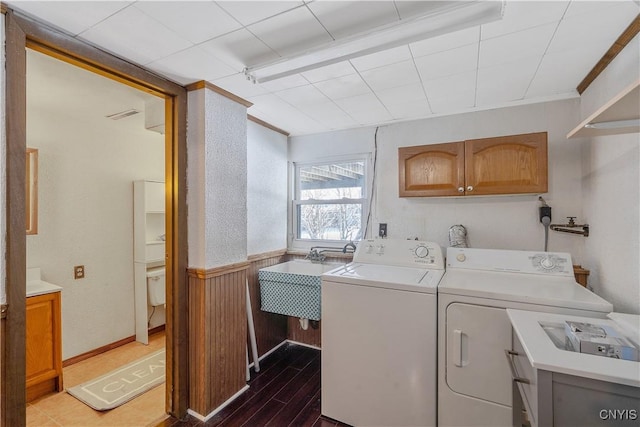 laundry room with cabinets, light hardwood / wood-style floors, sink, and washer and dryer