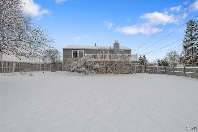 snow covered house featuring a wooden deck