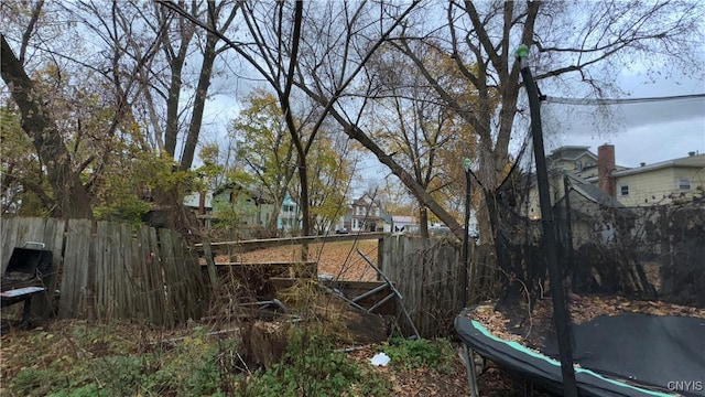 view of yard with a trampoline and a water view