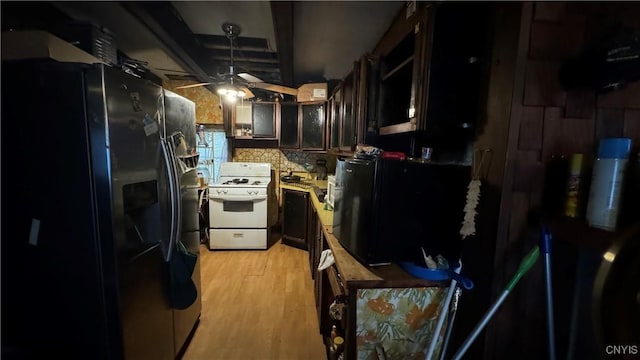 kitchen with stainless steel fridge, ceiling fan, dark brown cabinetry, white gas stove, and light wood-type flooring