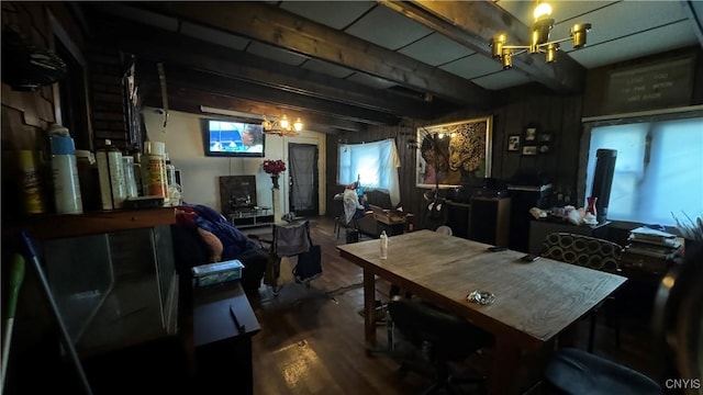 dining room with a notable chandelier, beam ceiling, and hardwood / wood-style flooring