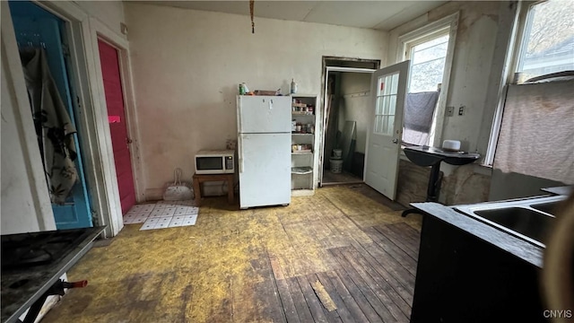 kitchen featuring hardwood / wood-style flooring and white fridge