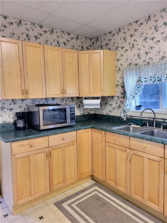 kitchen with light brown cabinetry, sink, and a paneled ceiling