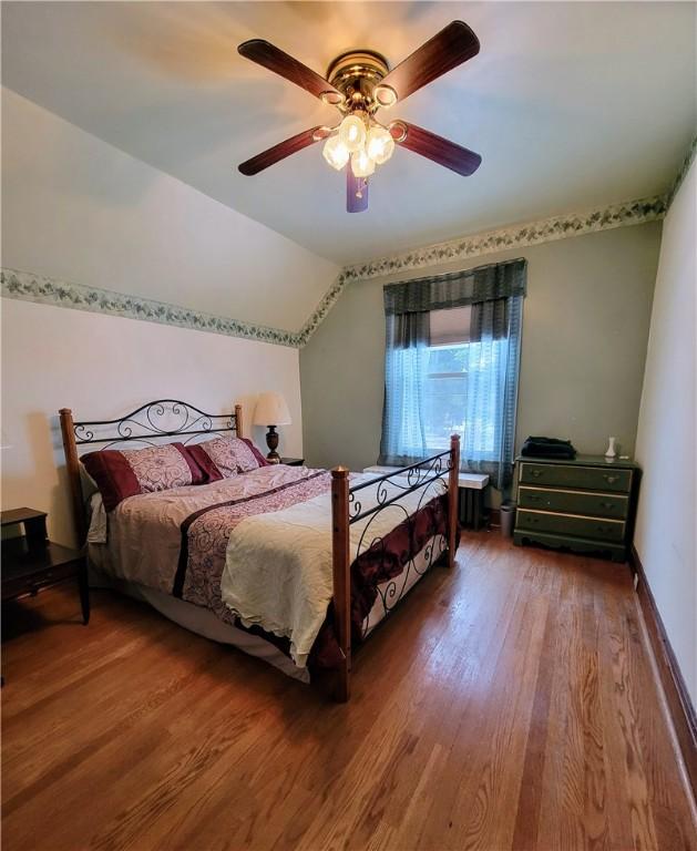 bedroom featuring lofted ceiling, wood-type flooring, and ceiling fan