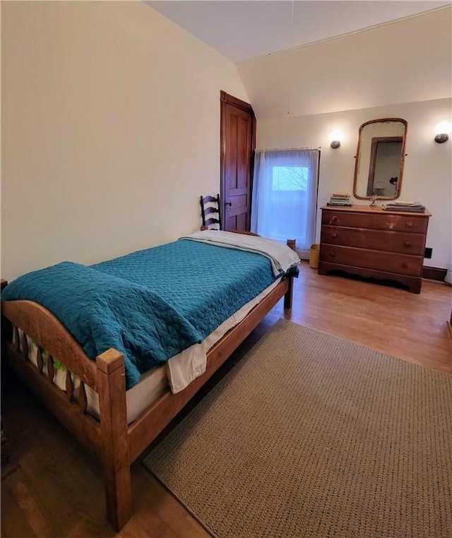 bedroom featuring vaulted ceiling and light hardwood / wood-style floors