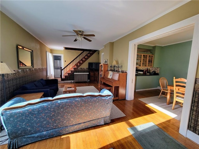 living room featuring ceiling fan, ornamental molding, radiator heating unit, and wood-type flooring