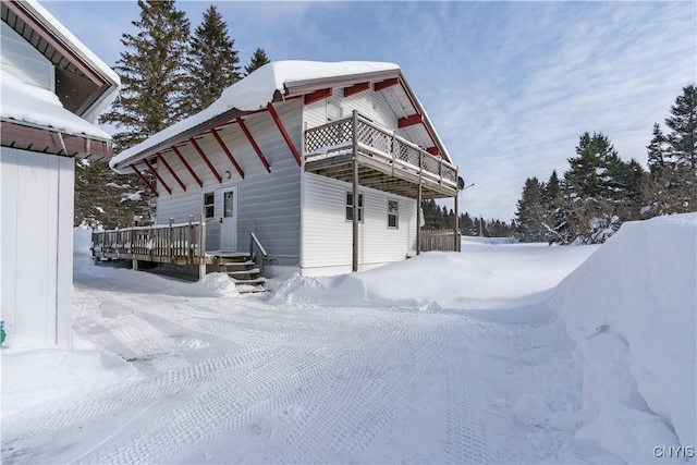 view of snow covered exterior with a deck