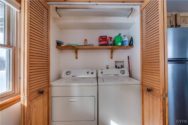 clothes washing area with water heater and washer and dryer