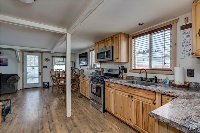 kitchen with light brown cabinetry, sink, light hardwood / wood-style flooring, and appliances with stainless steel finishes