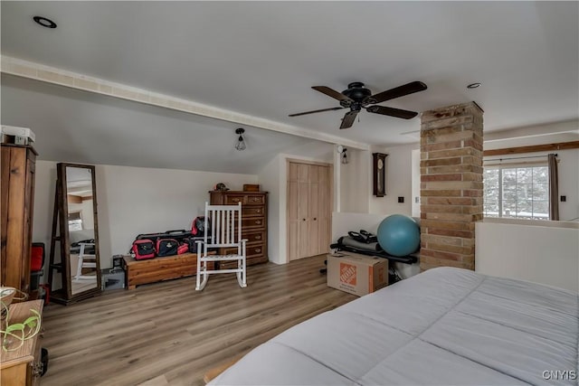 bedroom with ceiling fan, lofted ceiling, and light wood-type flooring