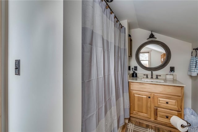 bathroom featuring lofted ceiling and vanity