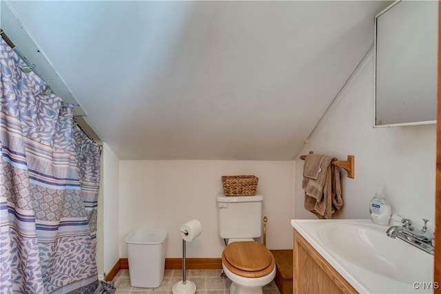 bathroom featuring tile patterned flooring, vanity, vaulted ceiling, and toilet