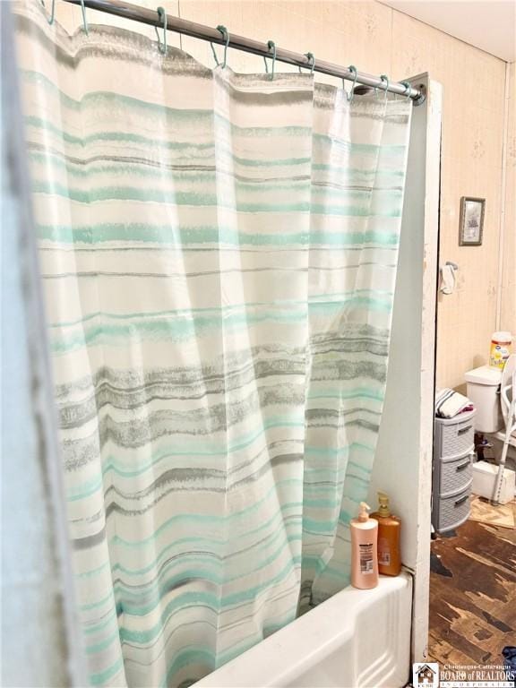 bathroom featuring hardwood / wood-style floors and shower / bath combination with curtain