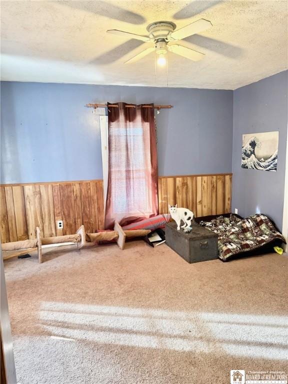 unfurnished bedroom featuring carpet floors, a textured ceiling, and wood walls