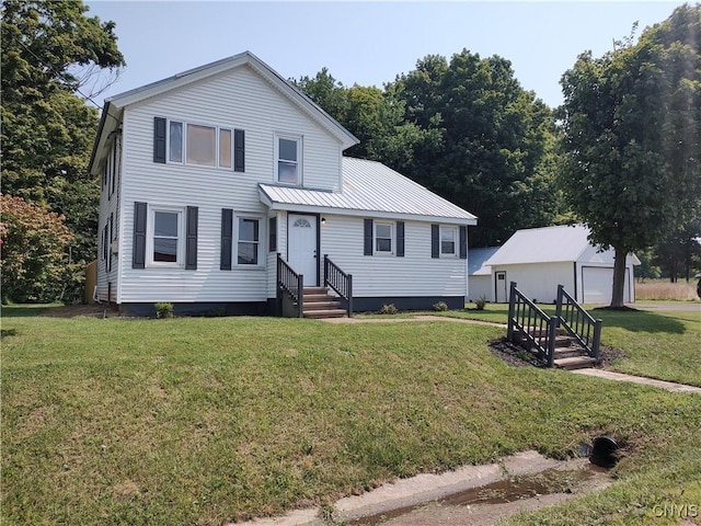 view of front of house featuring a garage, an outdoor structure, and a front lawn