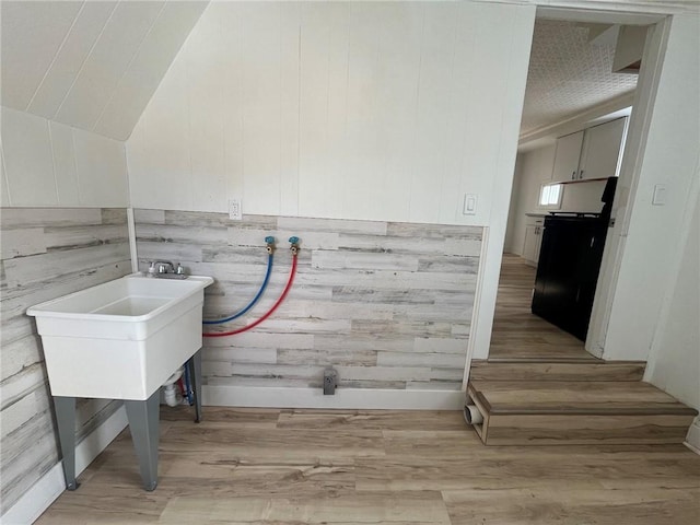 clothes washing area featuring washer hookup and light hardwood / wood-style flooring