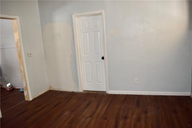 unfurnished room with dark hardwood / wood-style flooring