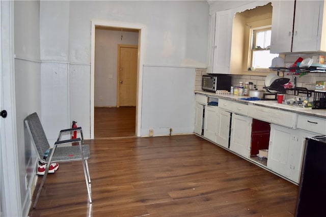 kitchen with dark wood-type flooring, decorative backsplash, and white cabinets