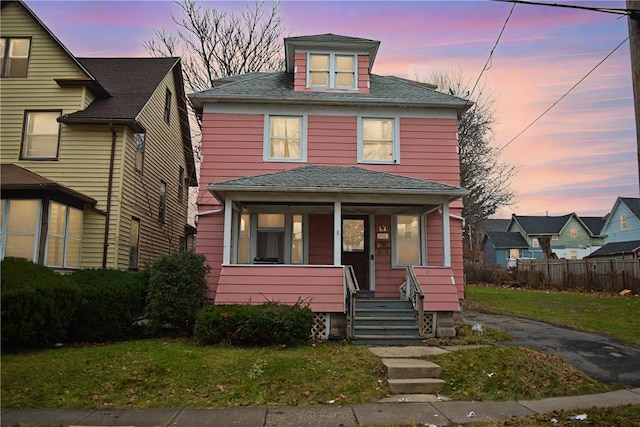 view of front of house with covered porch and a lawn