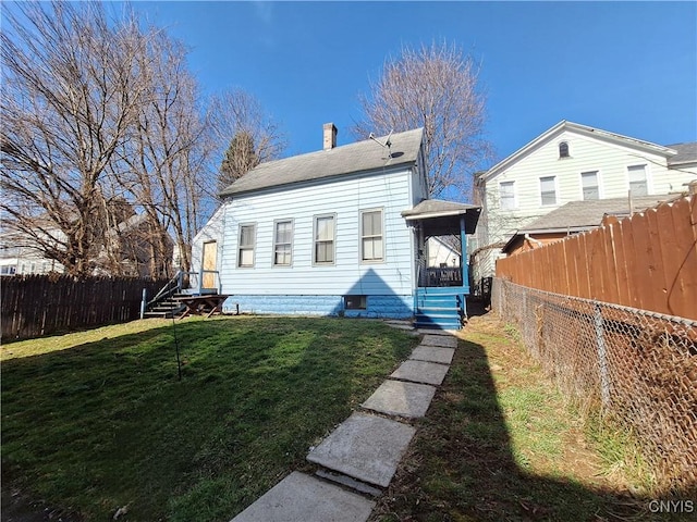 rear view of house featuring a yard