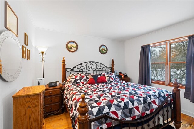 bedroom with ornamental molding and hardwood / wood-style floors