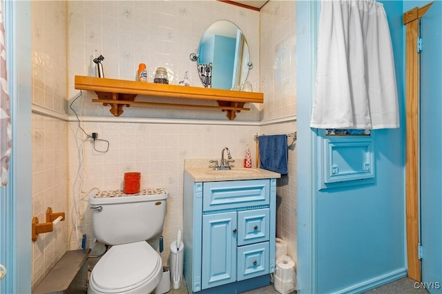 bathroom with vanity, tile walls, and toilet