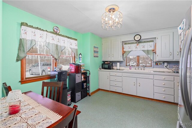 kitchen with sink, hanging light fixtures, and white cabinets