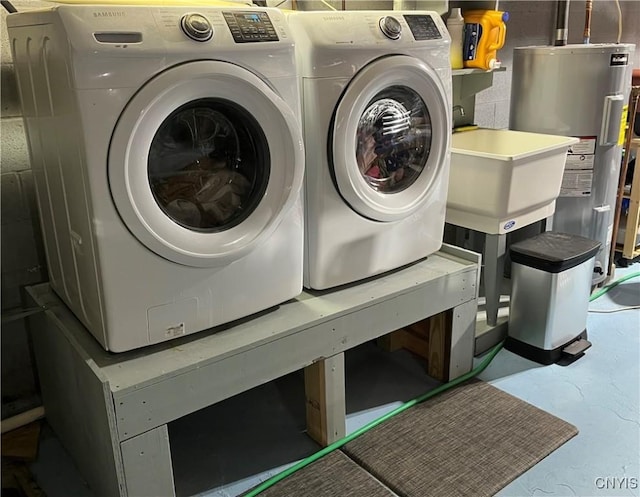 clothes washing area featuring electric water heater and washing machine and dryer