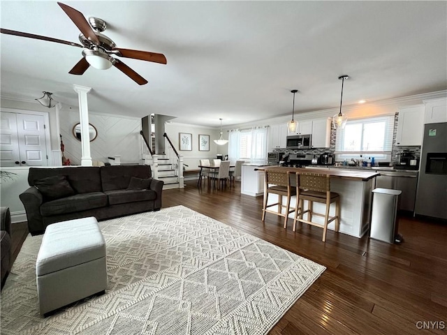 living room featuring crown molding, ceiling fan, and dark hardwood / wood-style flooring