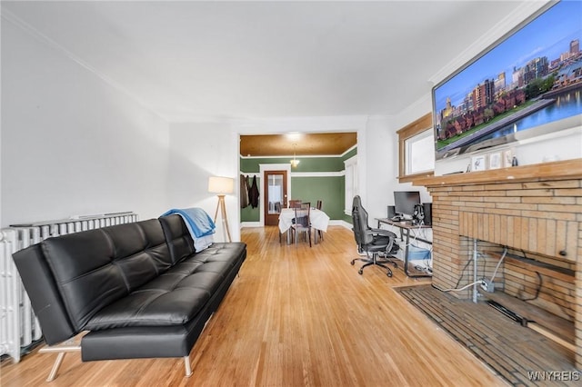 living room featuring radiator, hardwood / wood-style flooring, and built in desk