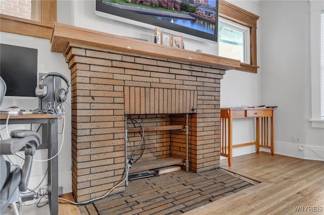 details featuring hardwood / wood-style floors and a brick fireplace