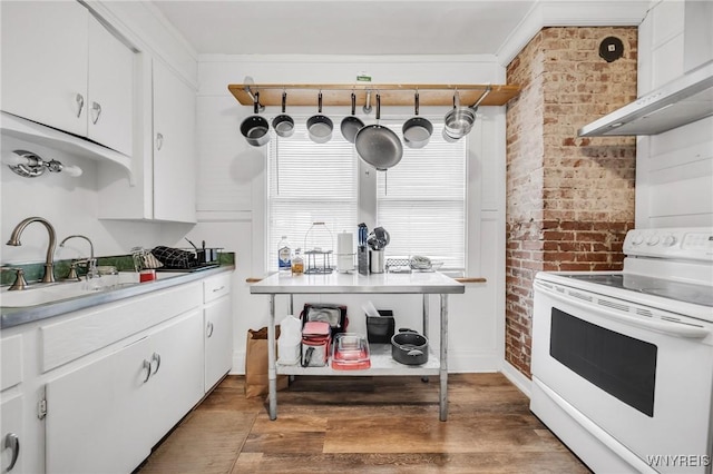 kitchen featuring electric stove, sink, wall chimney exhaust hood, and white cabinets