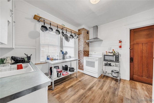 kitchen with crown molding, electric range, light hardwood / wood-style flooring, and wall chimney exhaust hood