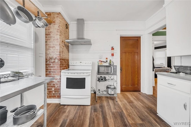 kitchen with electric stove, wall chimney range hood, white cabinetry, dark hardwood / wood-style floors, and ornamental molding