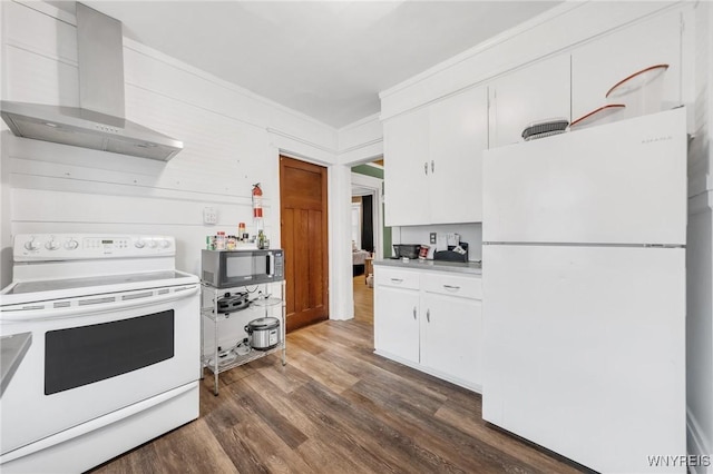 kitchen featuring wall chimney range hood, white appliances, white cabinetry, ornamental molding, and dark hardwood / wood-style flooring