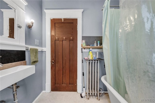 bathroom with radiator heating unit and shower / bath combo