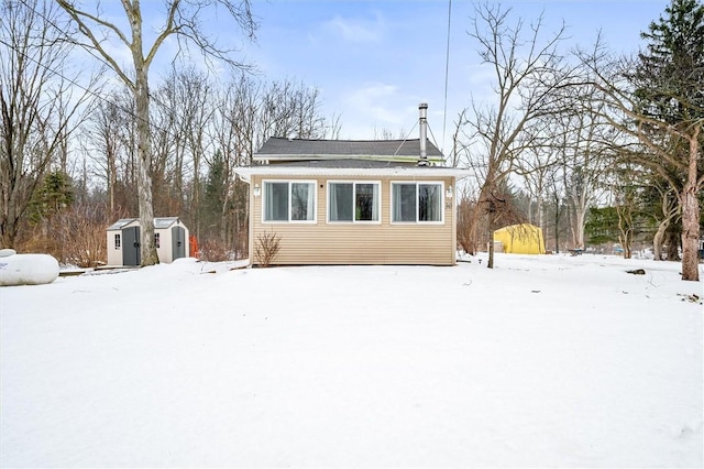 snow covered property featuring a shed