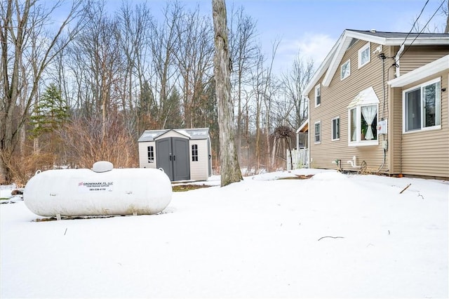 yard layered in snow with a storage unit