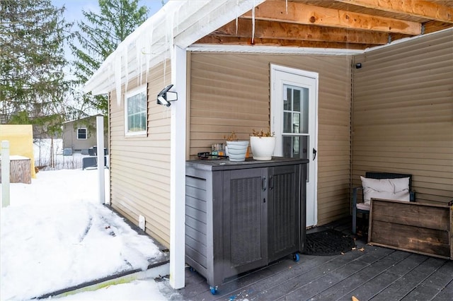 view of snow covered exterior with a wooden deck